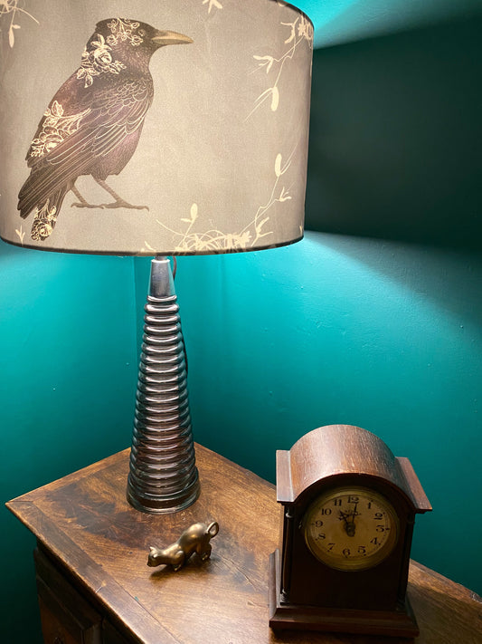One of a kind smoked glass lamp with velvet raven shade by DP Art pictured on a wooden unit with a vintage clock